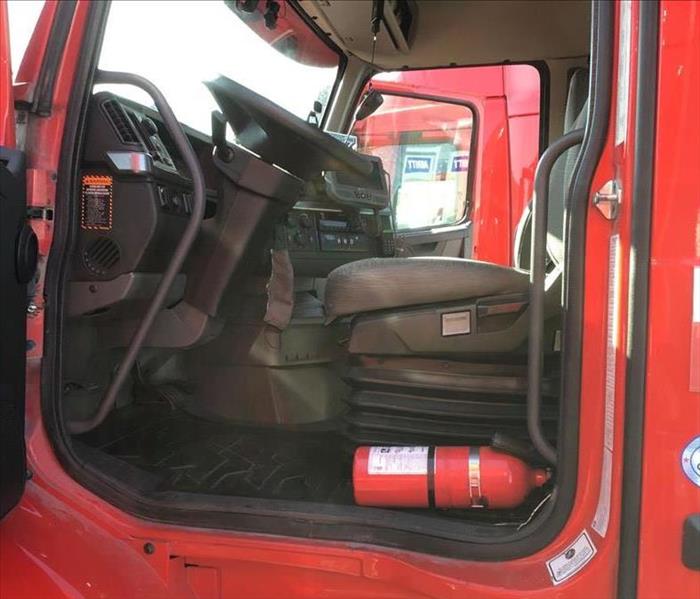 red semi-truck with door open and drivers seat showing 