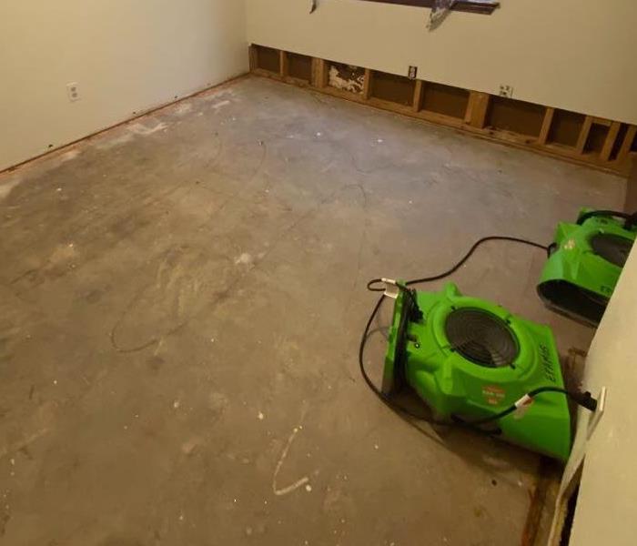 carpet removed in room with SERVPRO equipment drying area