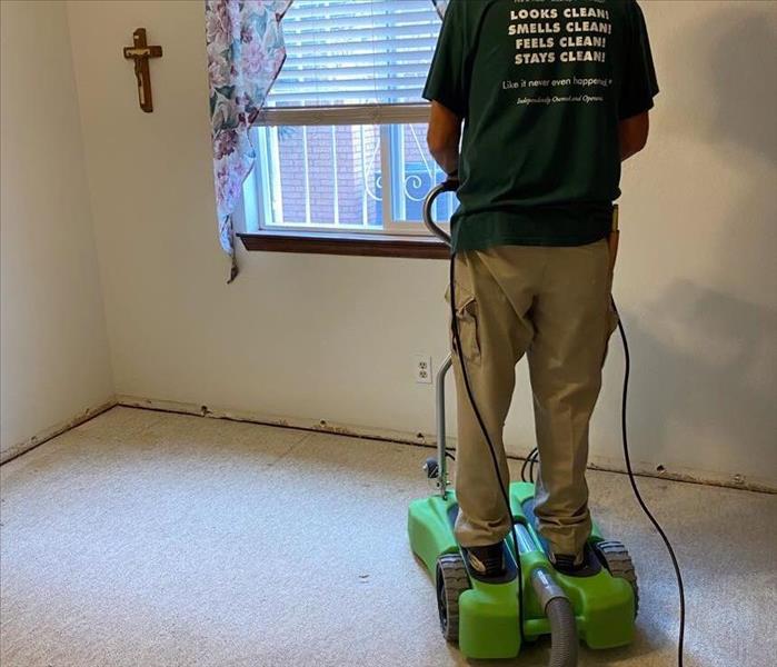male SERVPRO employee standing on water extraction machine