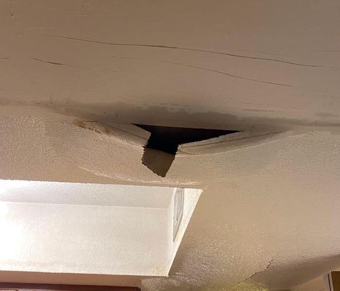 white ceiling with water damage and debris sticking out of it