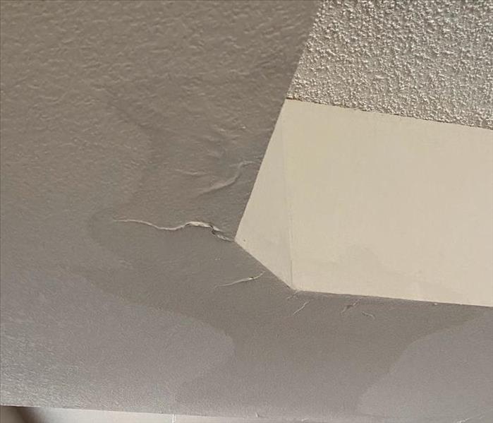 Water damaged ceiling with "sweat stains" and peeling paint